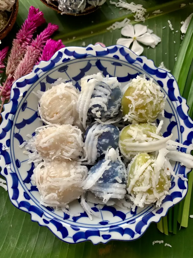 Top-down view of vegan coconut balls served in a blue and white bowl.