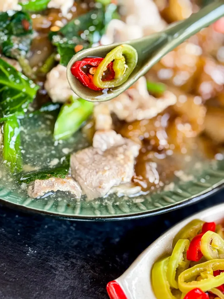 Close-up of Thai chili vinegar sauce spooned over rad na.