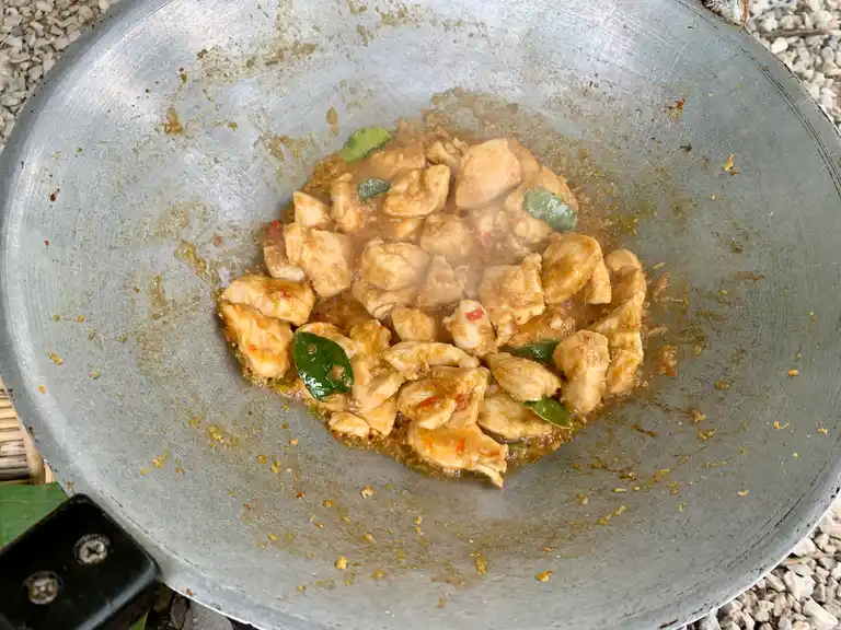 Thai lemongrass chicken stir fry with kaffir lime leaves in a wok, ready to serve.