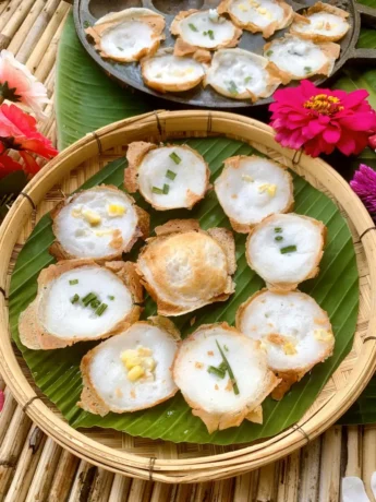 Kanom Krok on banana leaf - luscious Thai coconut pancakes, golden brown and crispy with a succulent, tender center, garnished with spring onions.
