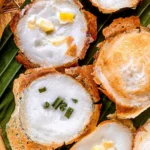 Close-up of kanom krok, Thai coconut milk pancakes, topped with green onions and corn.