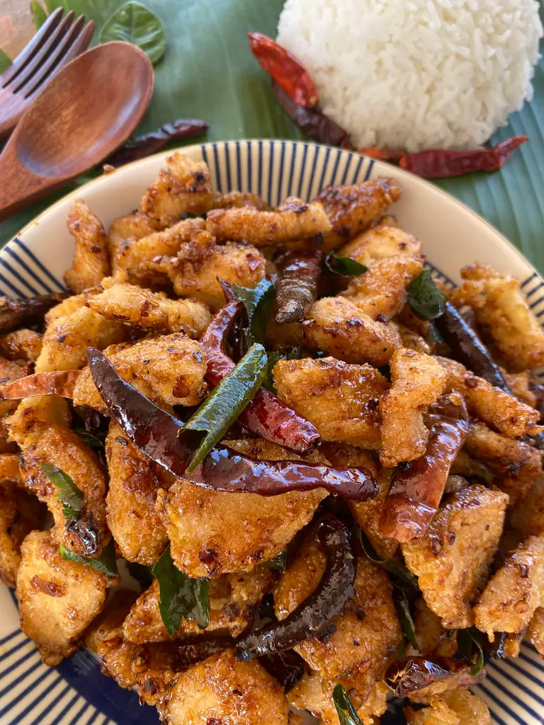 Close up of Thai pad prik haeng: crispy chicken with dried chilies, served with white rice.
