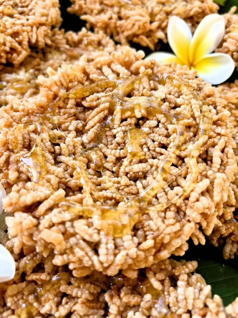 Close-up showing Thai khao taen, crispy rice crackers, drizzled with caramelized syrup made from palm sugar.