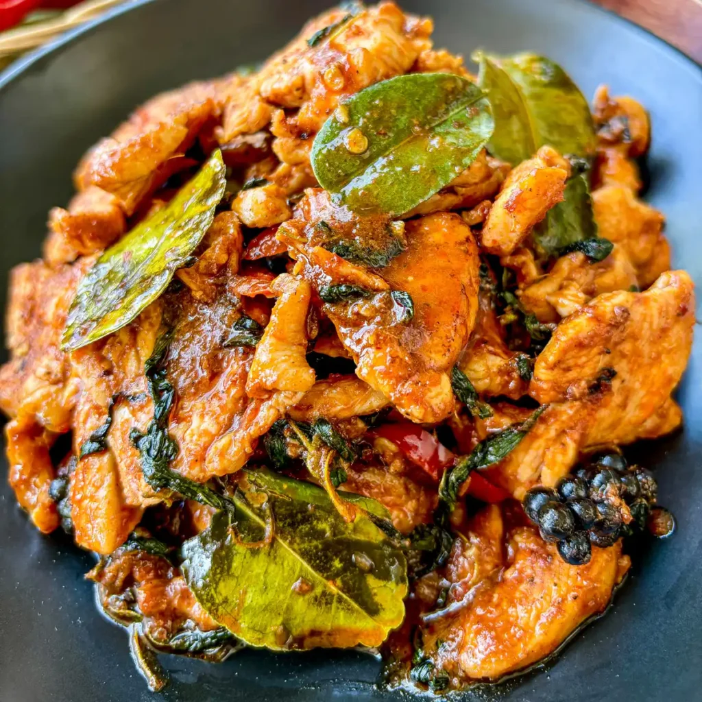 Thai pad ped chicken stir fry with red curry sauce and fresh herbs.