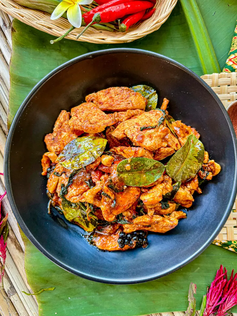 Thai chicken pad ped with kaffir lime leaves, chili, and holy basil in a rich curry paste.