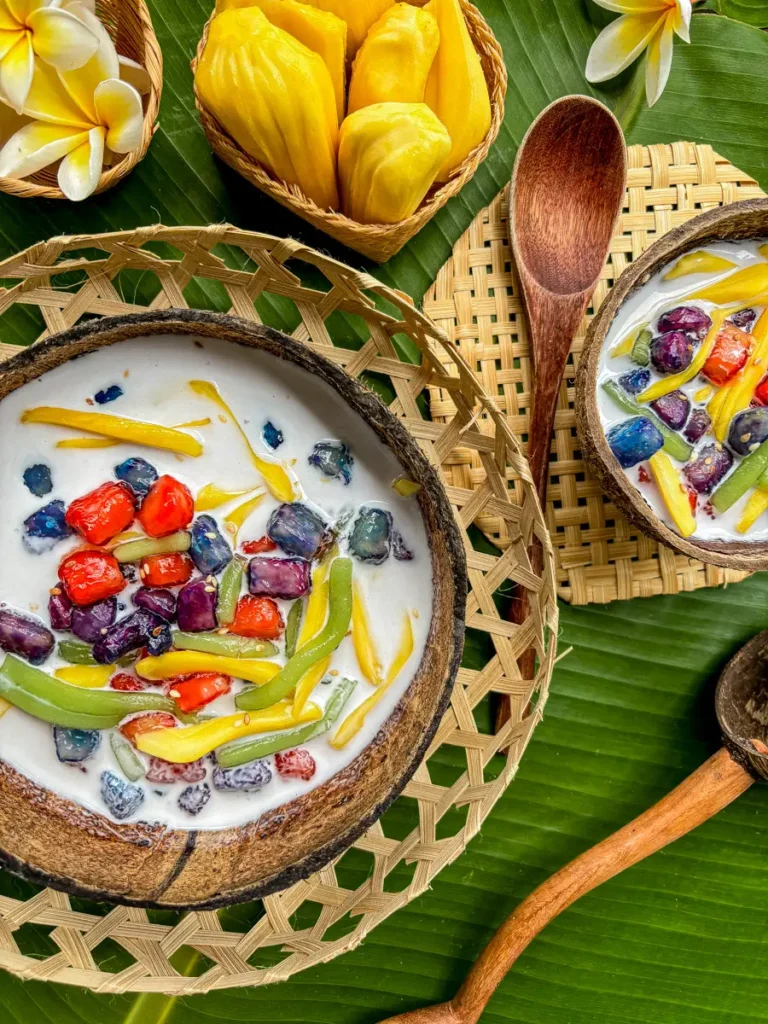 Two coconut bowls of Thai ruam mit dessert served on a banana leaf.