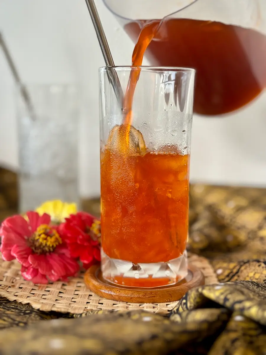 Cha manao, Thai lime ice tea, poured in a glass.
