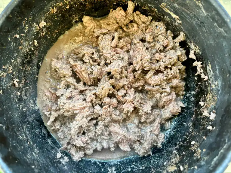 Cooked ground beef in a pot, steaming and ready for seasoning.