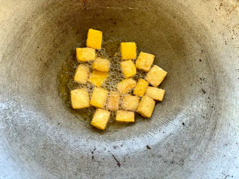 Crispy fried tofu in a wok.