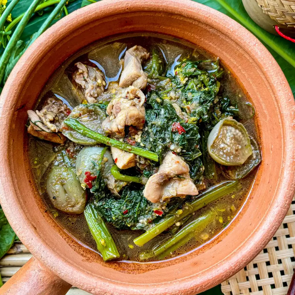 Gaeng om gai, a Northeastern Thai chicken and herb soup, complete with sticky rice in a bamboo container.