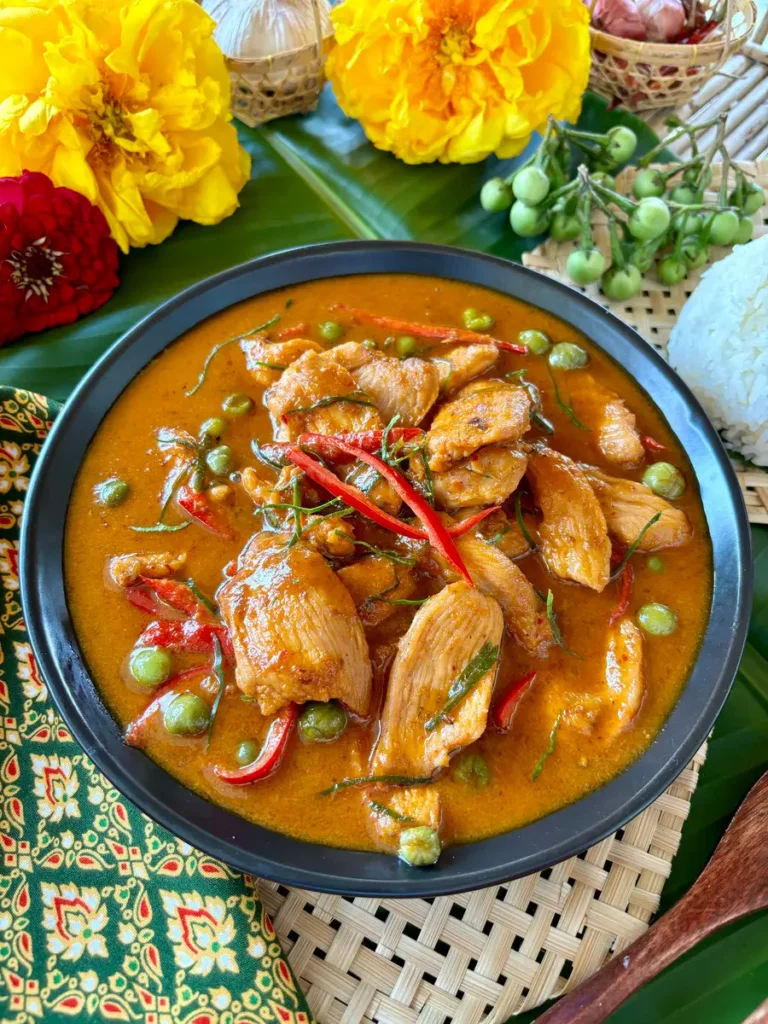 Close-up of homemade gaeng panang gai, showcasing tender chicken and spicy, saucy curry.