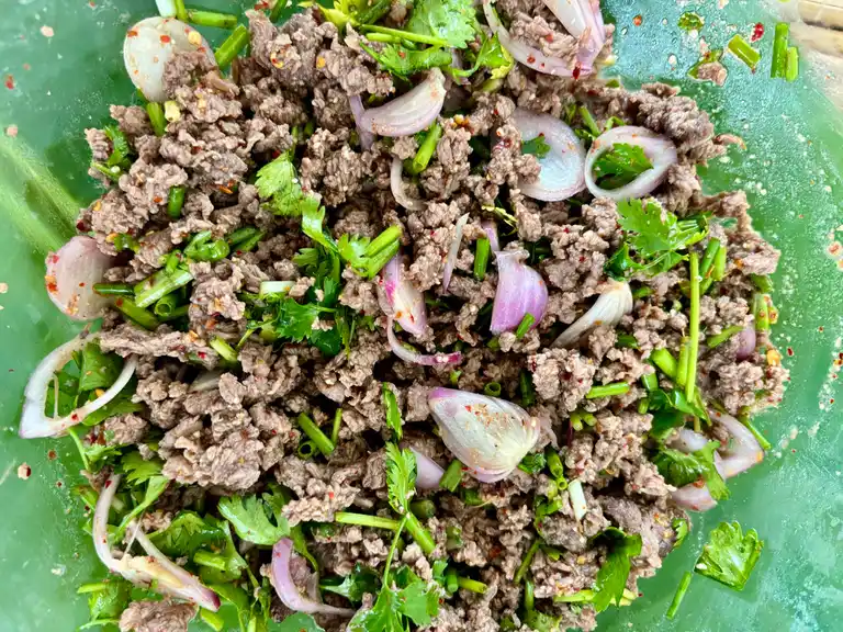 Seasoned ground beef tossed with herbs and shallots, ready for lettuce wraps.