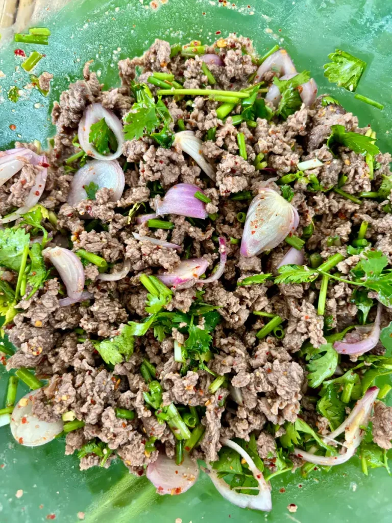 Close-up of seasoned ground beef tossed with Thai dressing and spices.