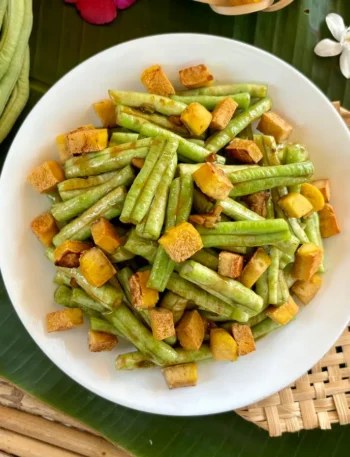 Long beans stir-fry with crispy tofu, served in a white dish.