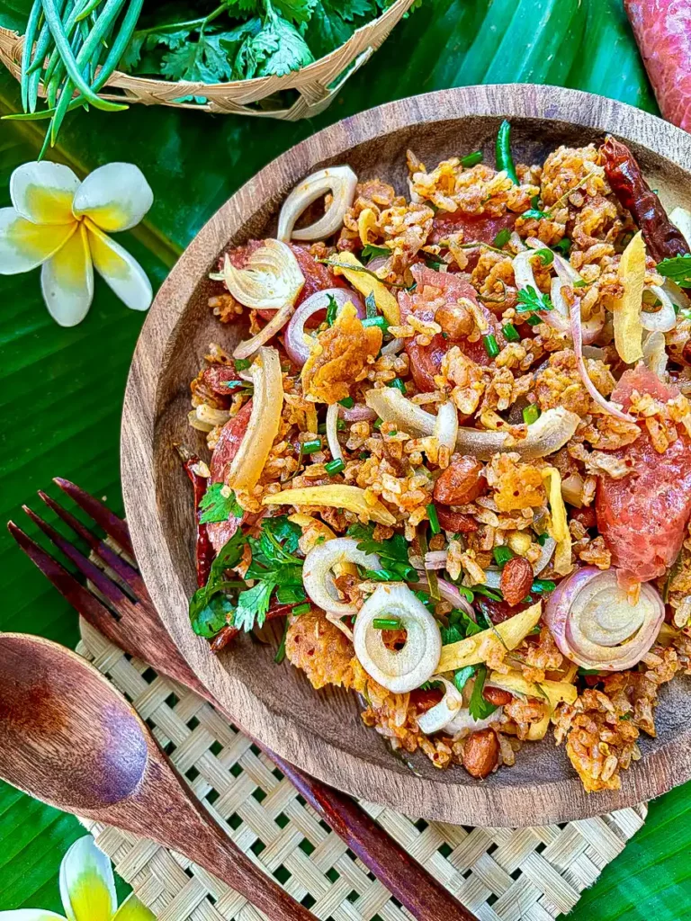 Traditional nam khao tod with crispy rice, tangy sausage, and peanuts.