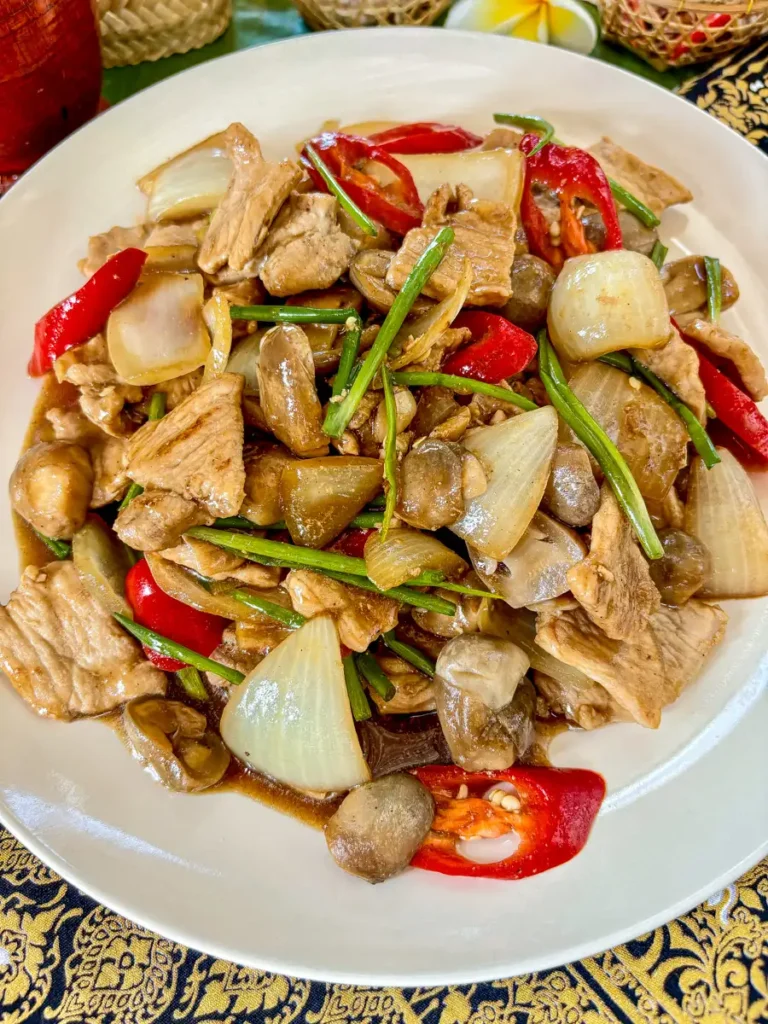 Pork with oyster sauce stir-fry with mushrooms and vegetables on a white plate.