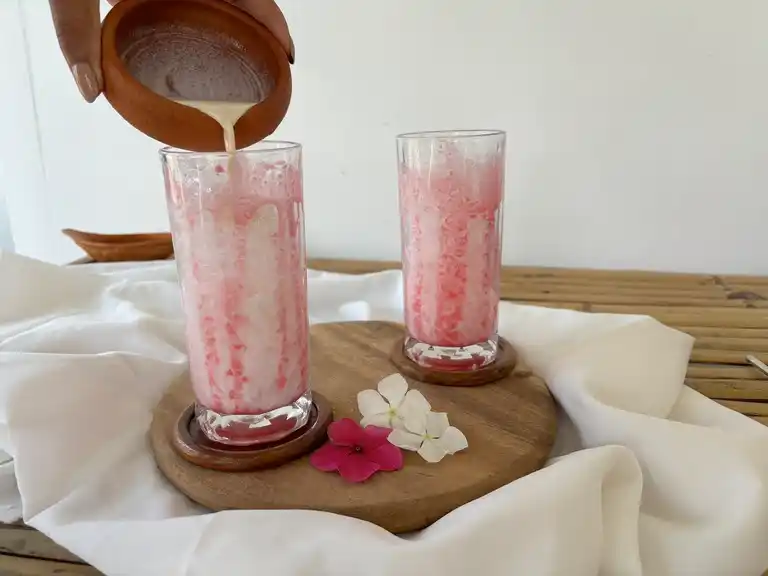 Pouring milk in glasses with ice and sala syrup.