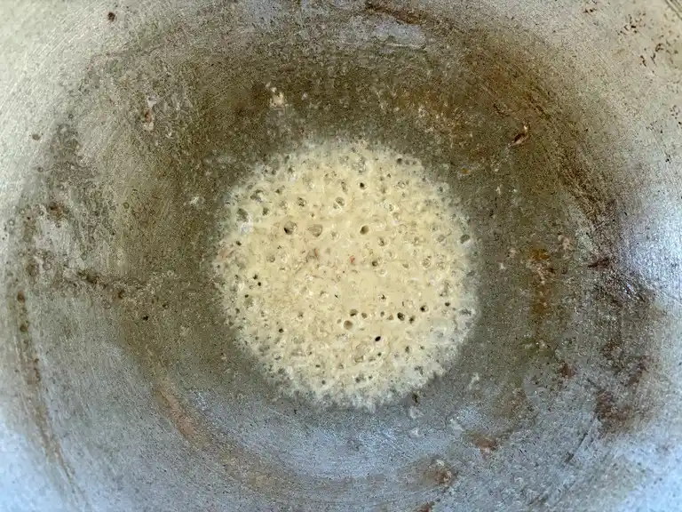 Coconut milk reducing in a wok.
