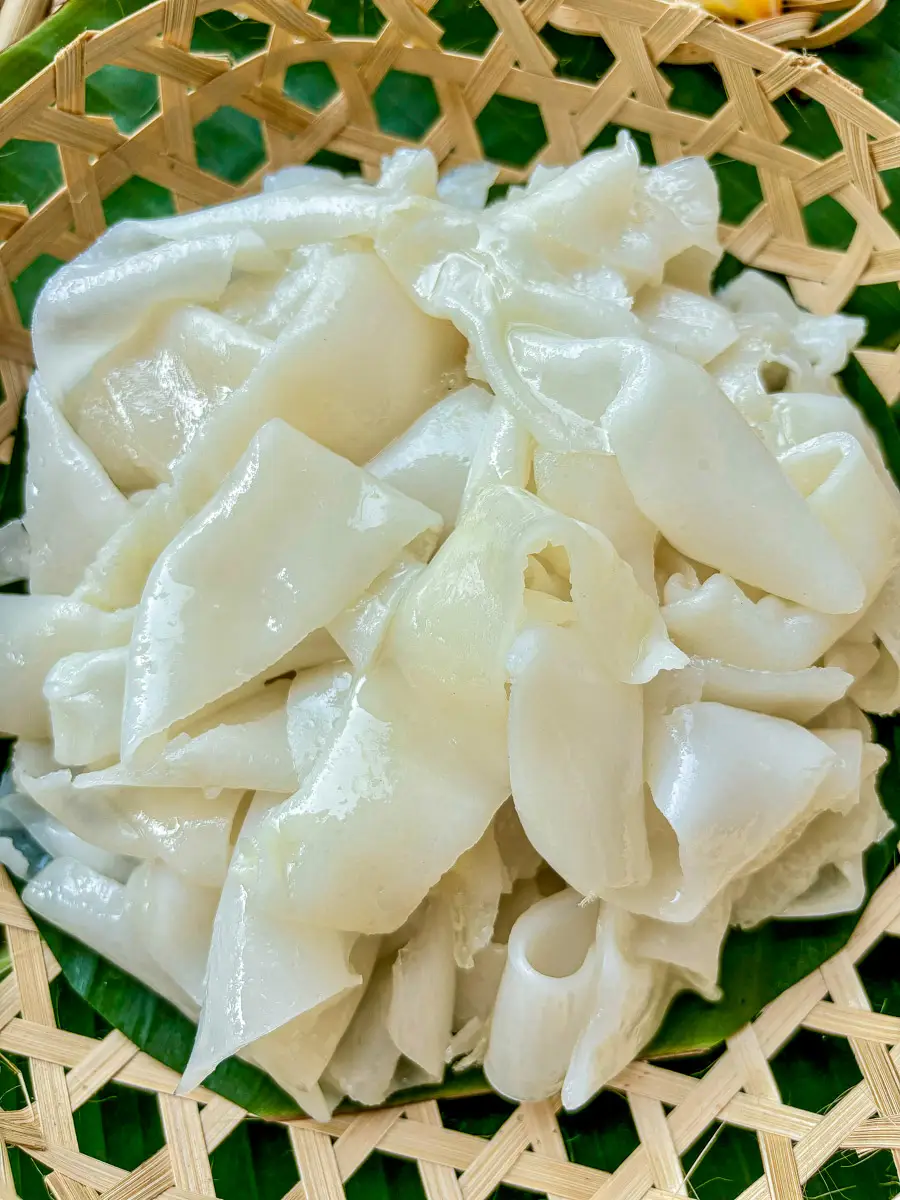 Close-up of homemade Thai sen yai noodles prepped for stir-frying.
