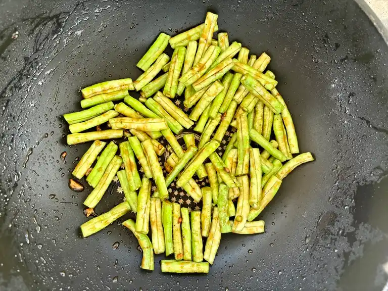 Stir-fried long beans ready in a wok.