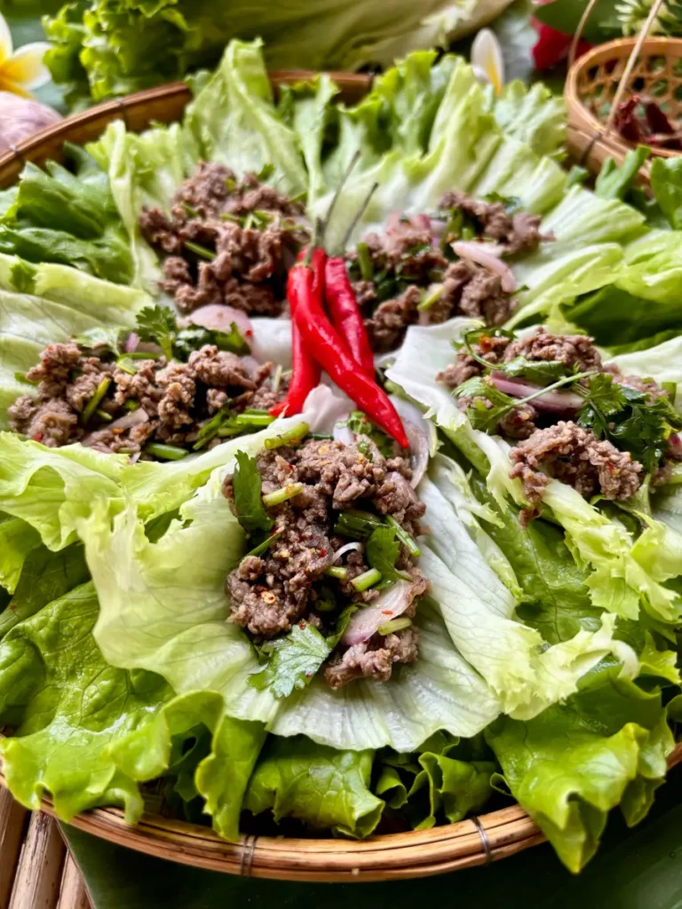 Thai ground beef lettuce wraps with chili arranged on a bed of lettuce.