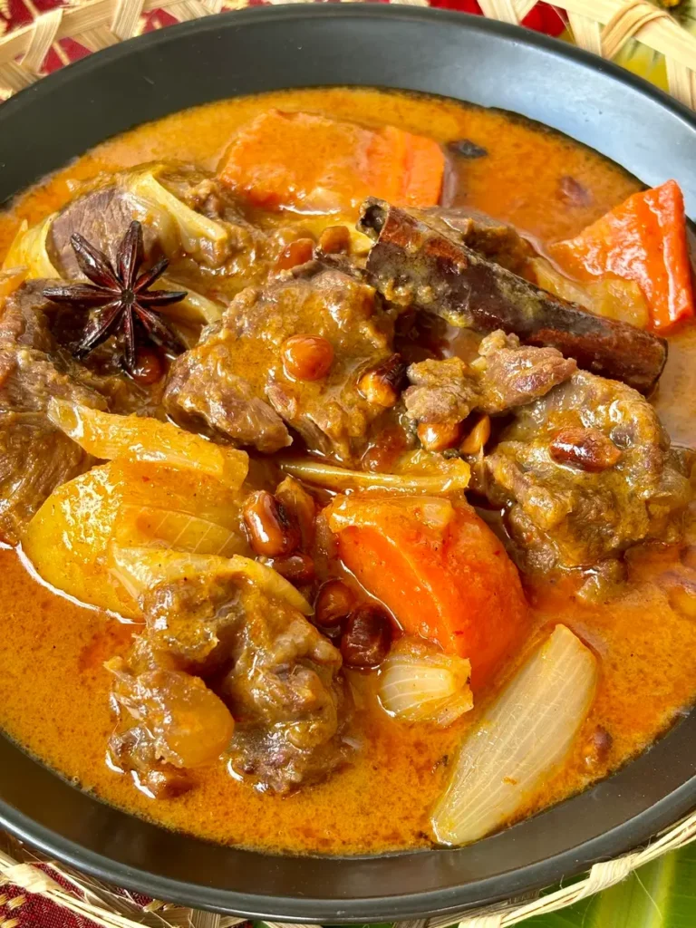 Close-up of Thai massaman beef curry with chunks of beef, carrots, and potatoes.