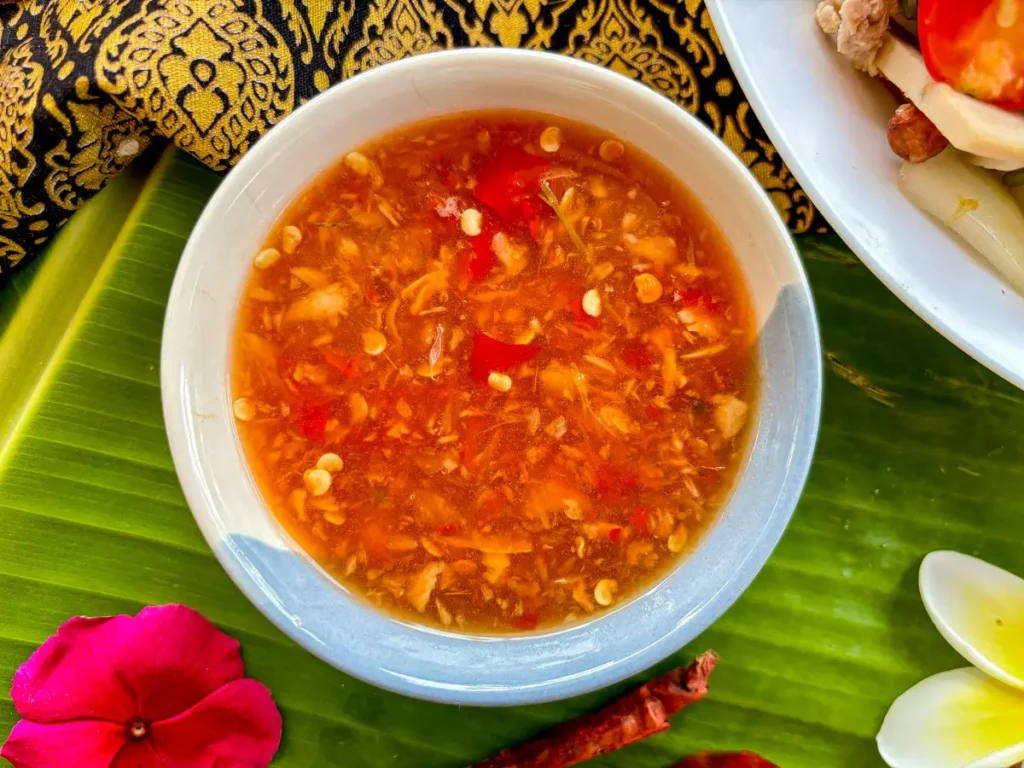 Thai salad dressing in a ceramic bowl on a banana leaf, a traditional setting.