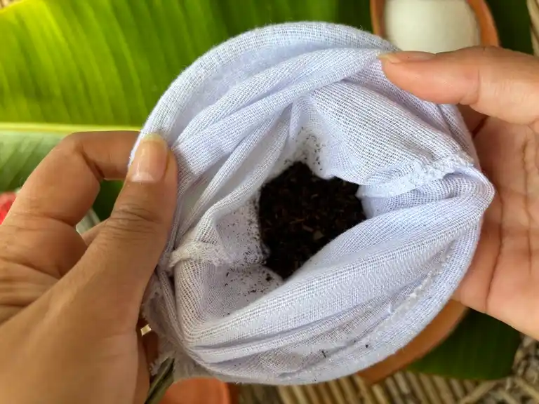 Thai tea leaves in a white cloth filter.
