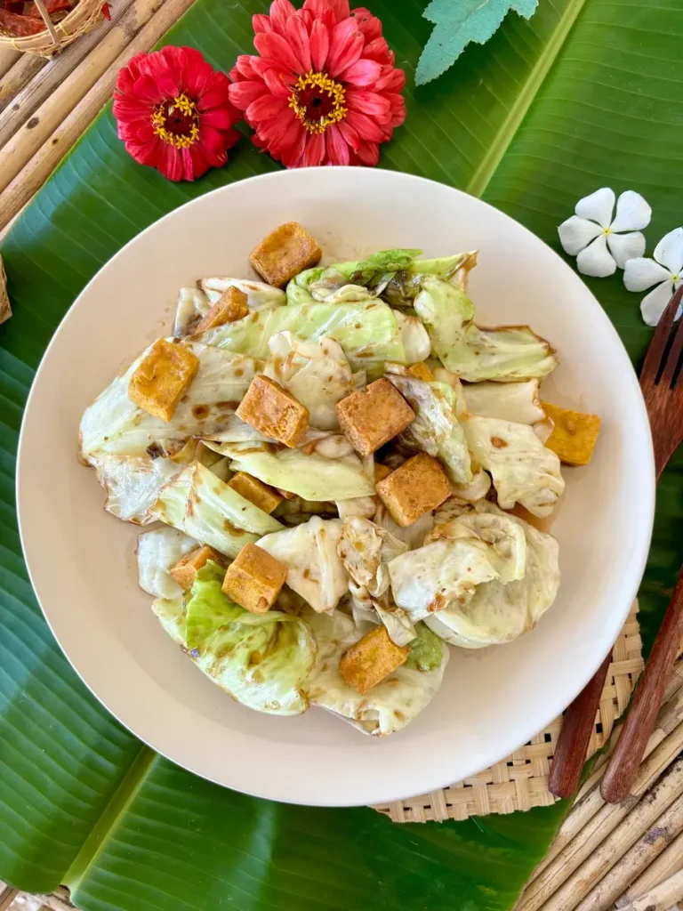 Vegetarian fried cabbage with tofu, Thai pad galam plee, served in a white dish.