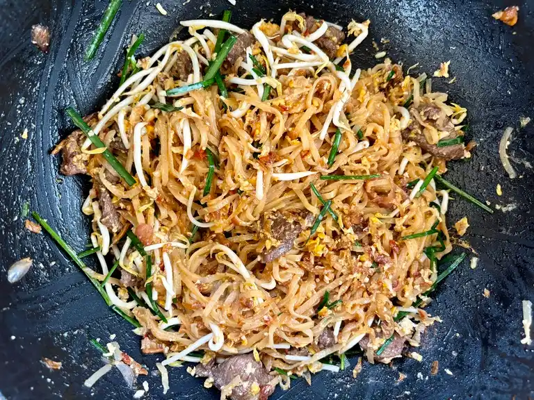 Beef pad Thai ready in a wok.