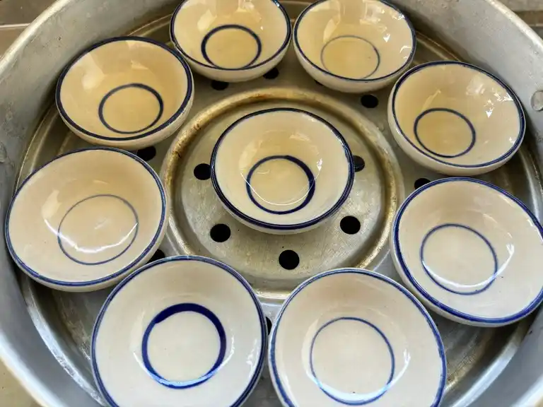 Ceramic bowls placed in a steamer.