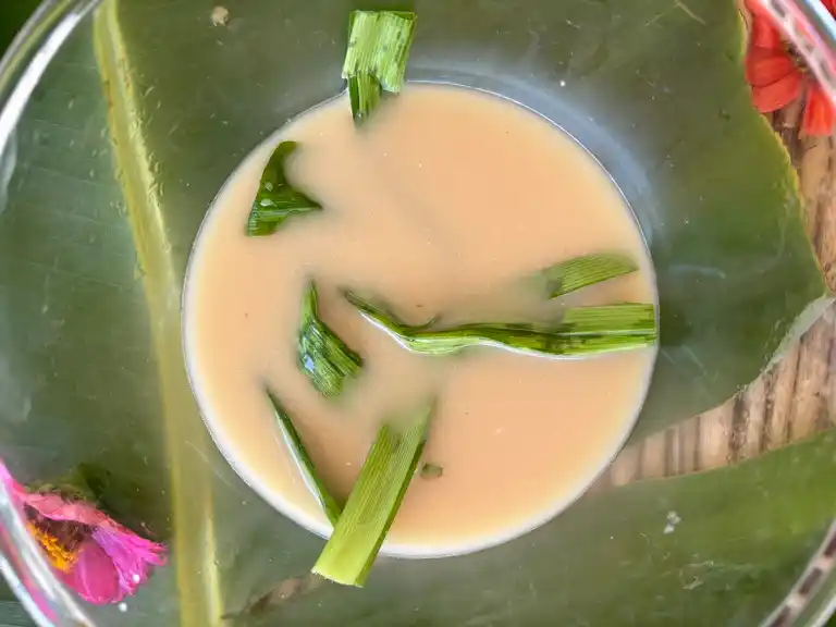 Coconut palm sugar and pandan leaves in a glass bowl.