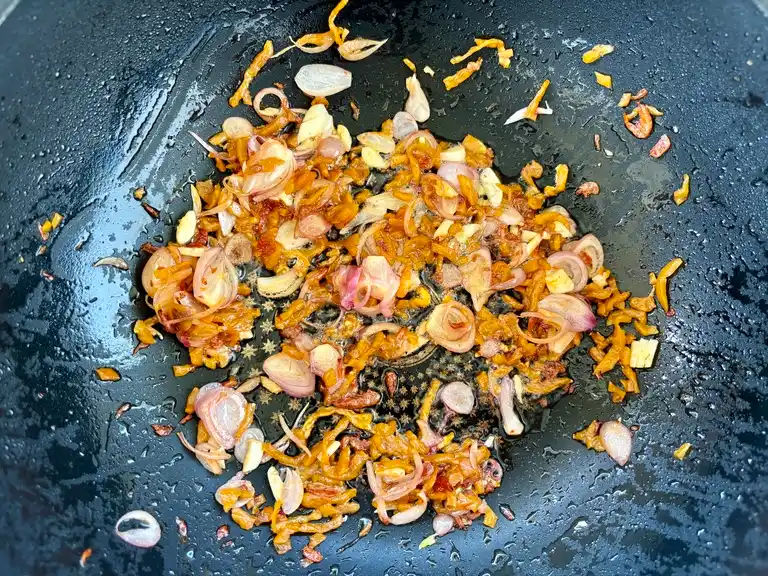 Golden fried shallots, garlic, and sweet preserved radish in wok.