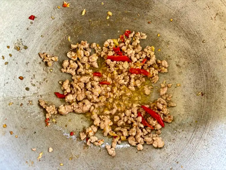 Ground pork with chili and garlic cooking in wok.