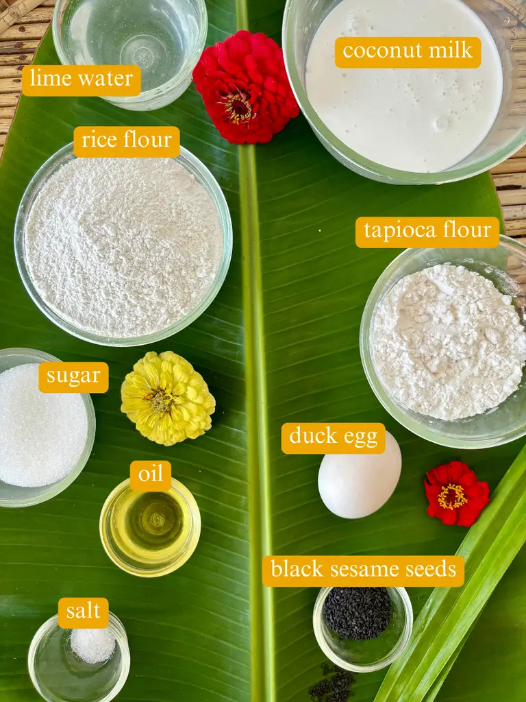 Ingredients for Thai lotus flower cookies labeled: lime water, coconut milk, rice flour, tapioca flour, white sugar, duck egg, oil, black sesame seeds, and salt.