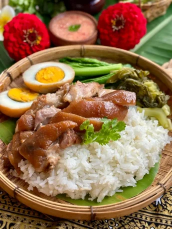 Khao kha moo, Thai braised pork leg, with hard-boiled eggs, jasmine rice, and pickled mustard greens.