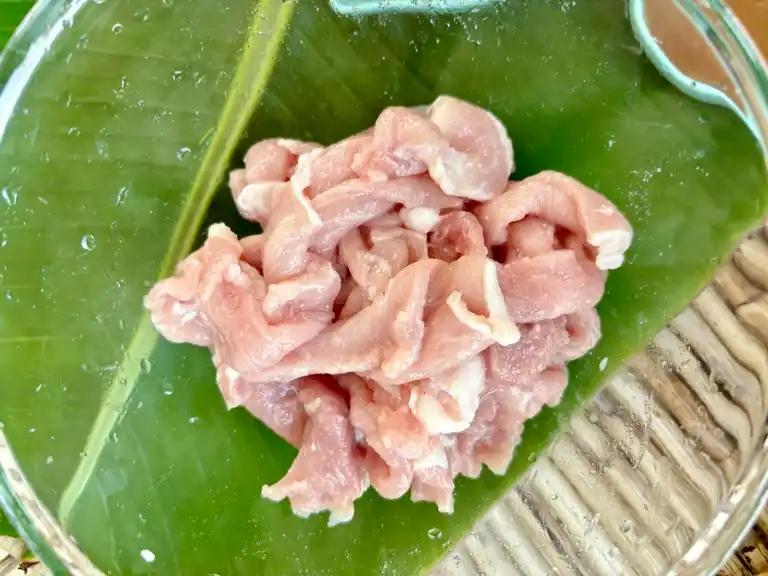 Marinated pork on a banana leaf.