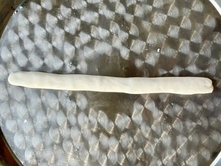 Raw dough rope on a flat surface.