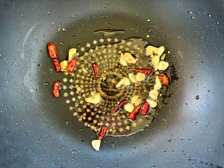 Sautéed garlic and chilies in a wok.