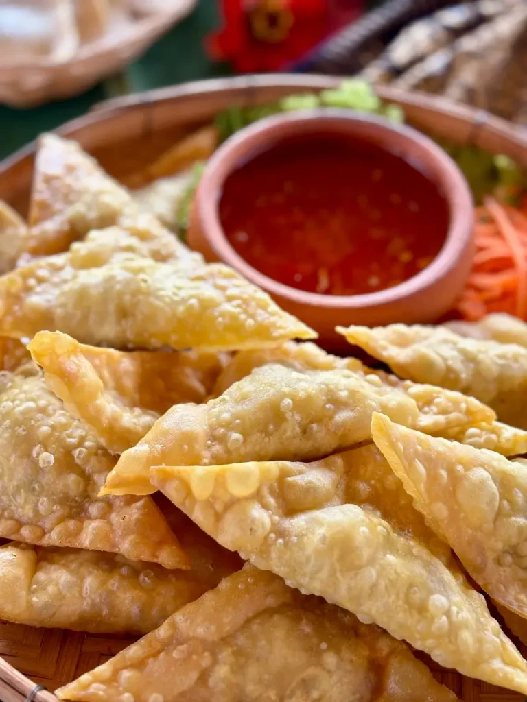 Close-up of Thai fried wontons with sweet chili dipping sauce.