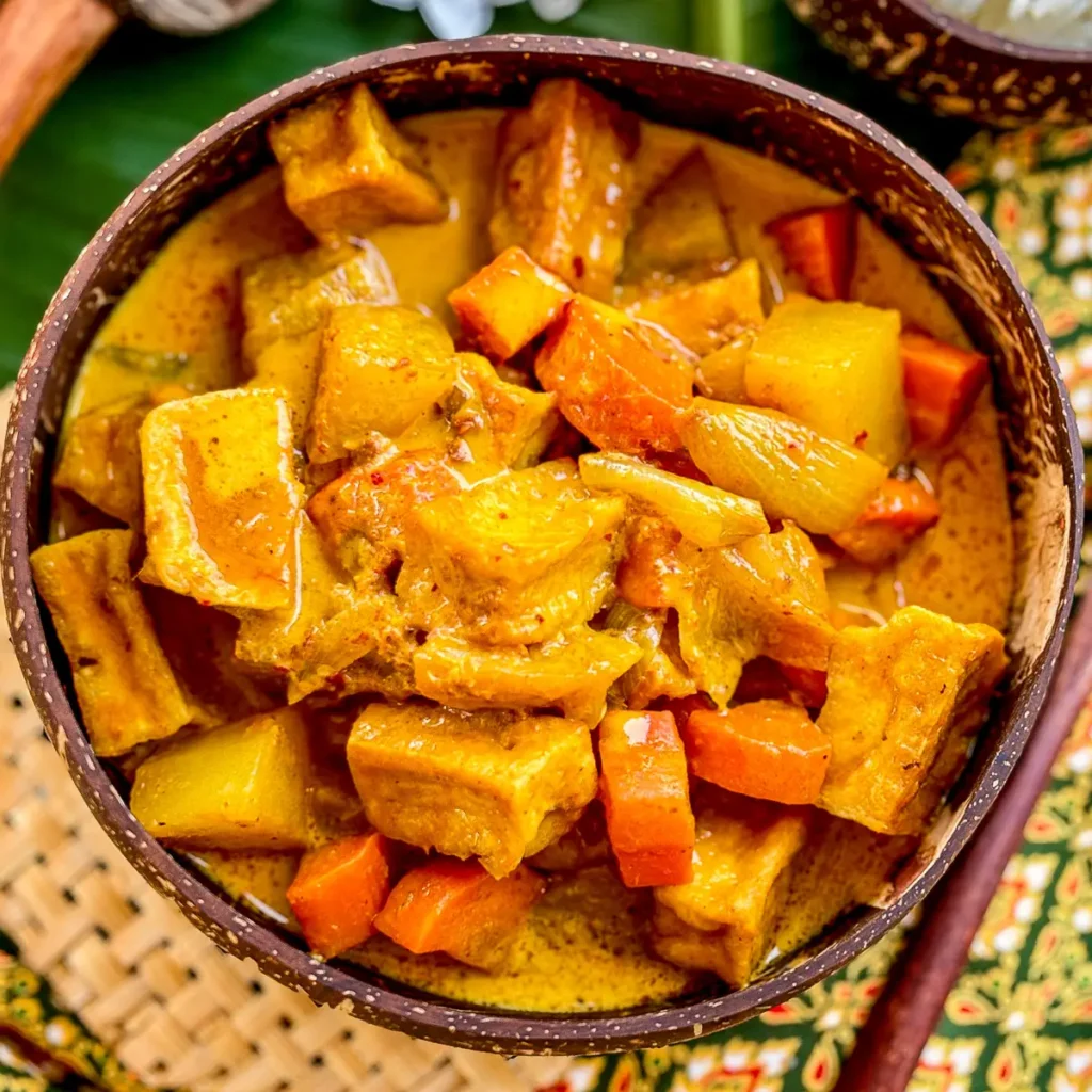 Thai vegan yellow curry with tofu, potatoes, and carrots in a rich coconut milk sauce.