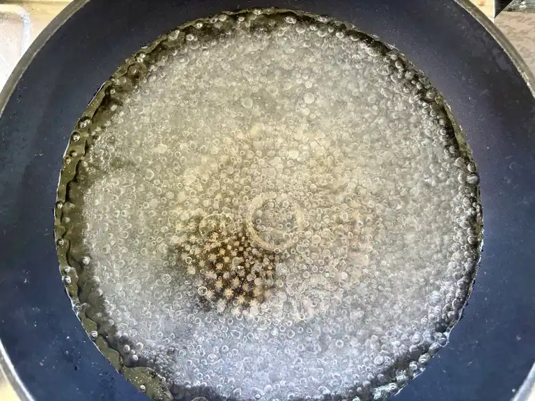 Water boiling in a wok pan.