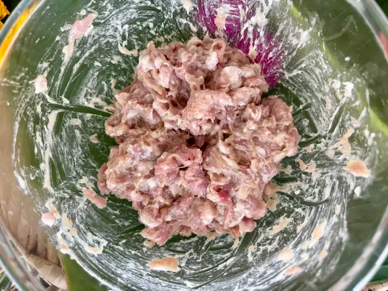 Thai pork wonton filling mixture in a clear bowl.