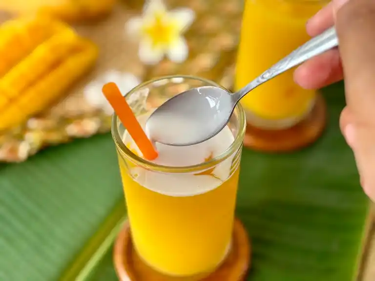 Coconut milk mango shake in a tall glass.