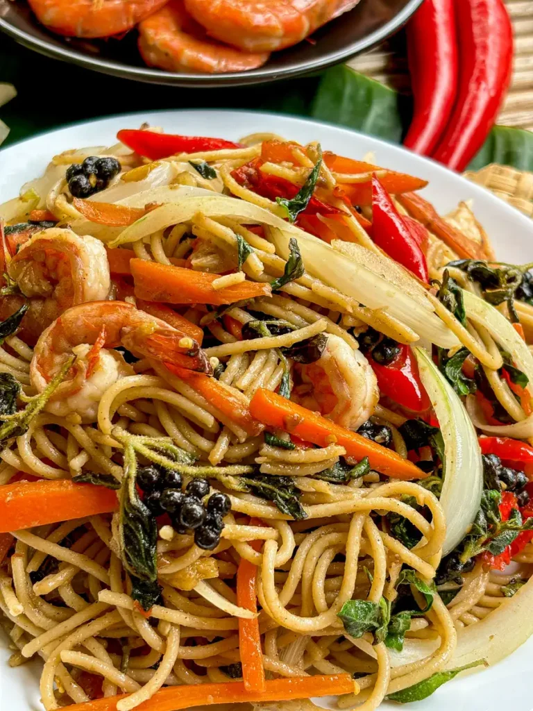 Close-up of spaghetti kee mao, Thai drunken spaghetti, in a white dish.