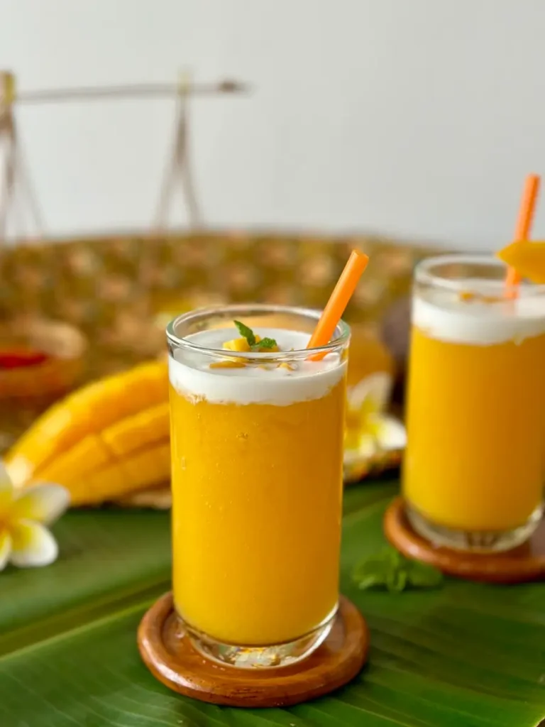 Thai mango drink with coconut milk served in tall glass.