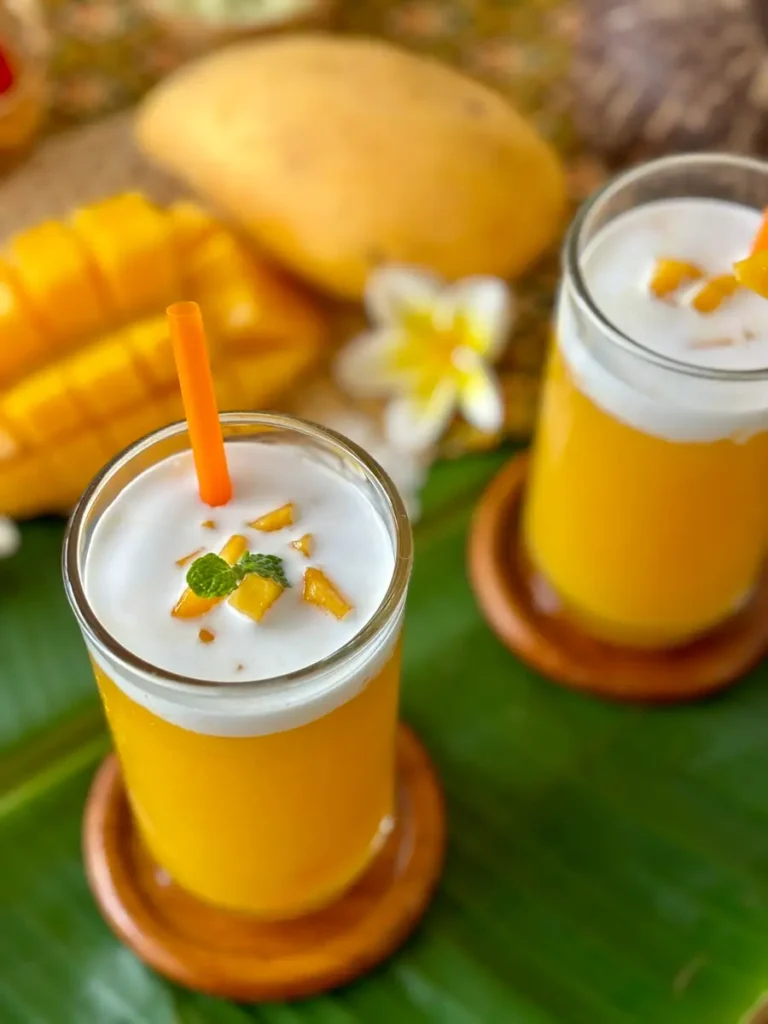 Two glasses of Thai mango shake, mamuang pan, topped with coconut milk.