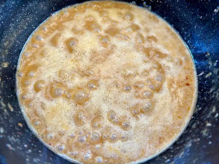 Thai peanut sauce cooking in a saucepan.