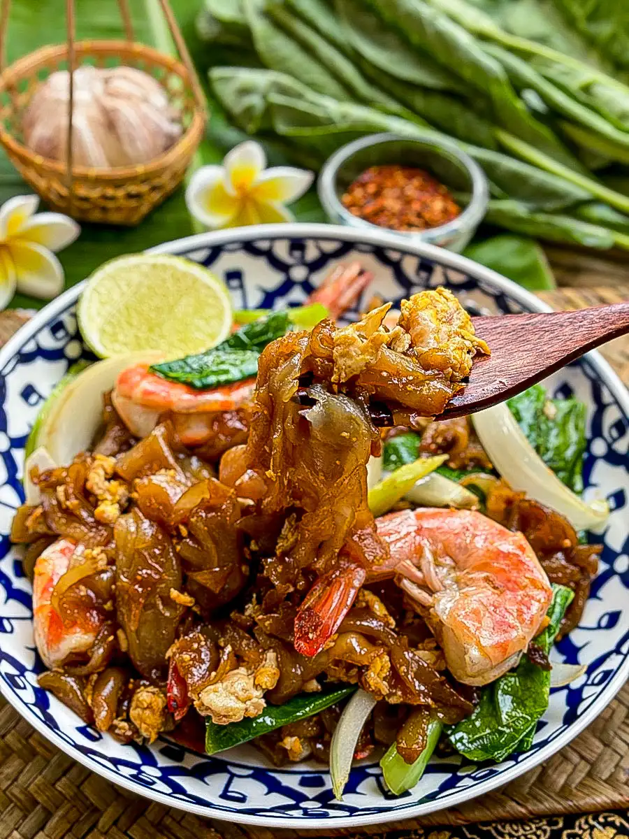 Stir-fried pad see ew with shrimp, wide rice noodles, Chinese broccoli, egg, and onion in a savory soy-based sauce.