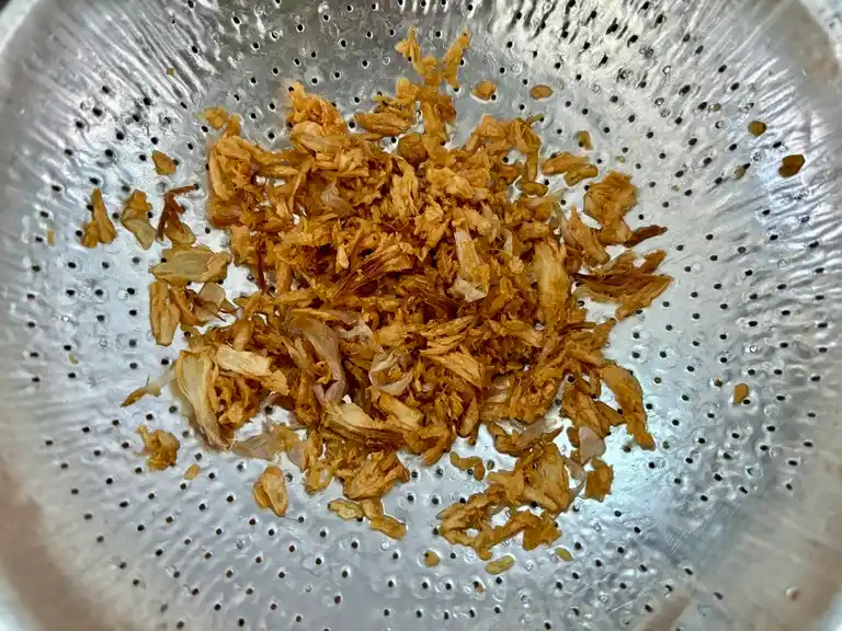 Crispy fried garlic excess oil drain in a sieve.